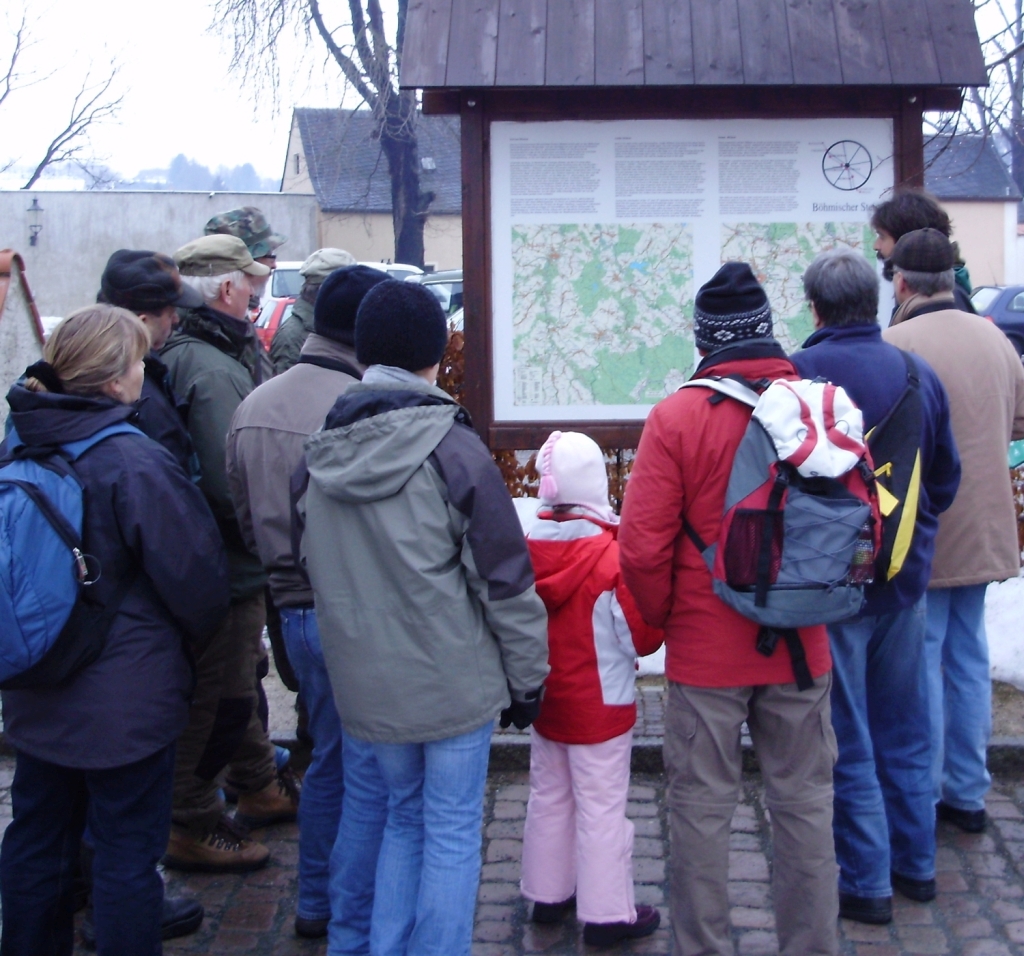 Gruppe von Menschen vor einer Wandertafel