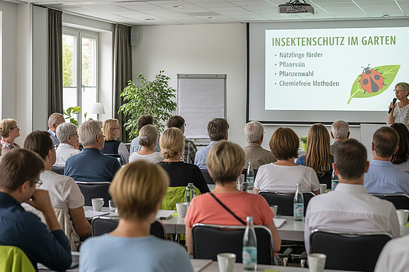 Einer Gruppe von Menschen, sitzt in einem Raum und lauscht gespannt einem Fachvortrag über „Insektenschutz im Garten“